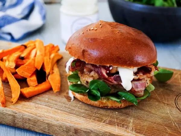 Boerderij kipburger met krokante buikspek, gepekelde ui en zoete aardappel friet