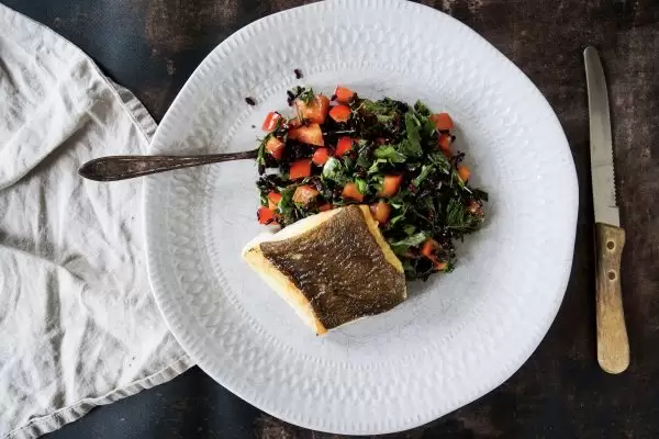 Wilde rijstsalade met groene kruiden en heilbot op de huid